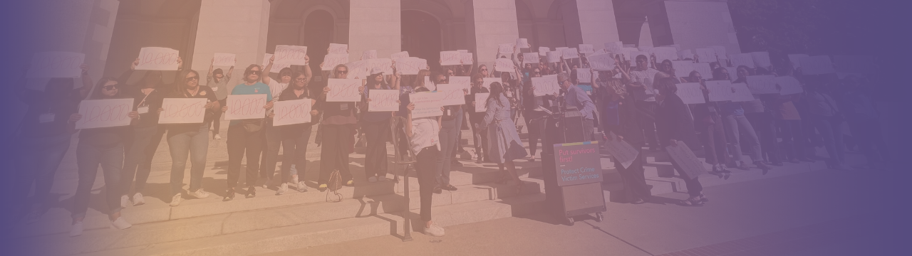 A crowd of people holding up signs in front of the Capitol, many of which read, "10,000" in circles with the number crossed out. A gold to purple overlay is on the picture.